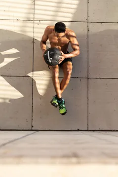 Runner holding a kettlebell on the pavement.