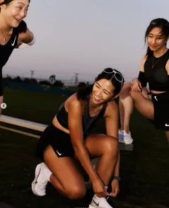 Athlete crouched beside teammates after training.